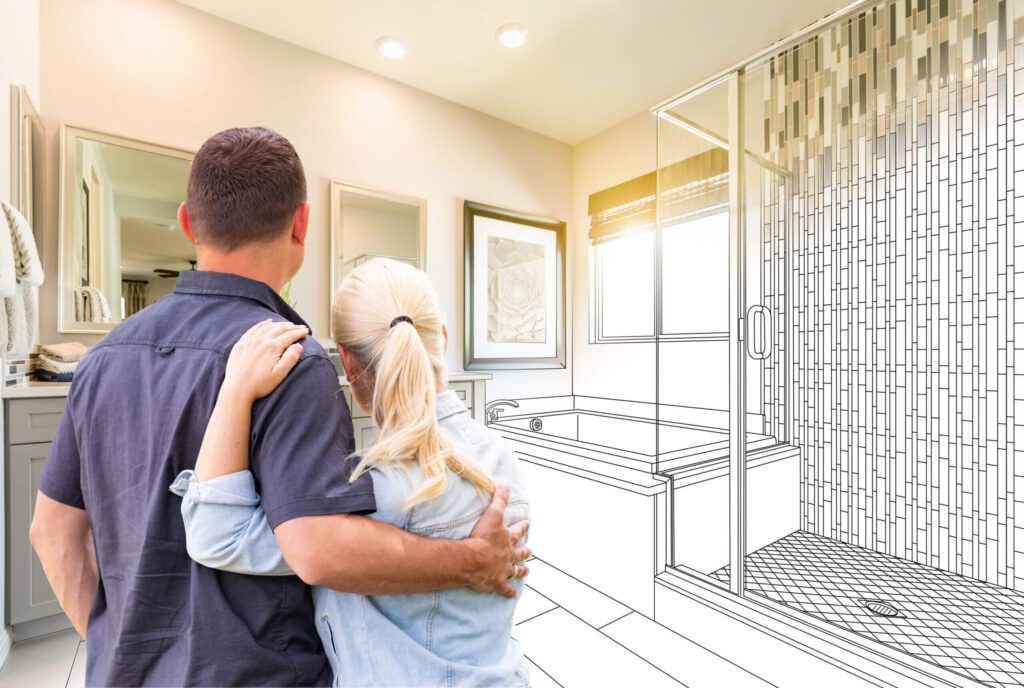 Couple standing close in a bathroom, looking at a mirror, with half of the image depicting a finished bathroom and the other half showcasing a line-drawn blueprint design of the space.